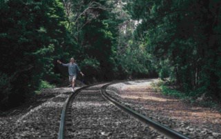Man walking on railway line in forest