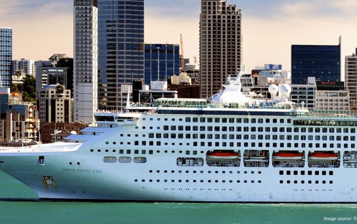 Cruise ship drifting past NZ city coastline.